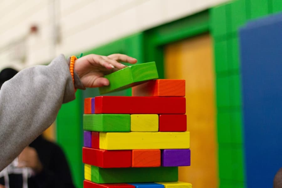 A child stacking colorful blocks during a therapy session